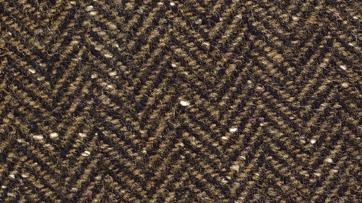 Tessuto tweed di lana a spina di pesce visto da vicino, con i piccoli bottoni di colore nel filato